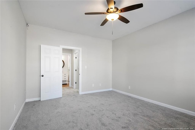 carpeted spare room featuring ceiling fan