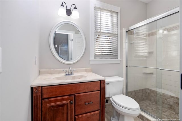 bathroom with toilet, vanity, and an enclosed shower