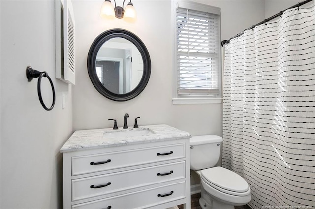 bathroom featuring vanity, toilet, and walk in shower