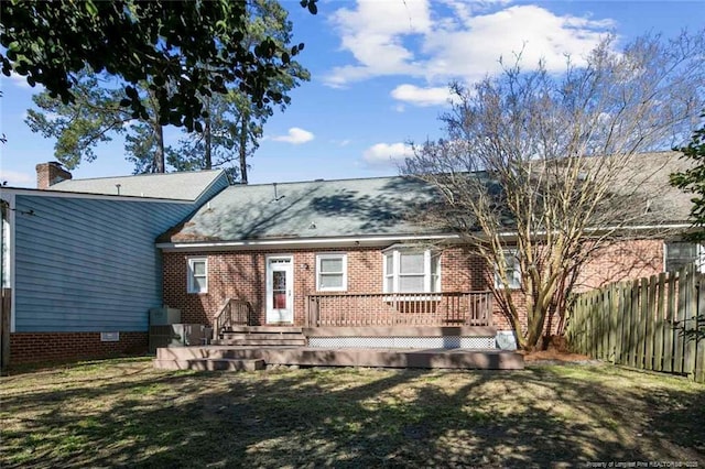 rear view of property featuring a deck and a lawn