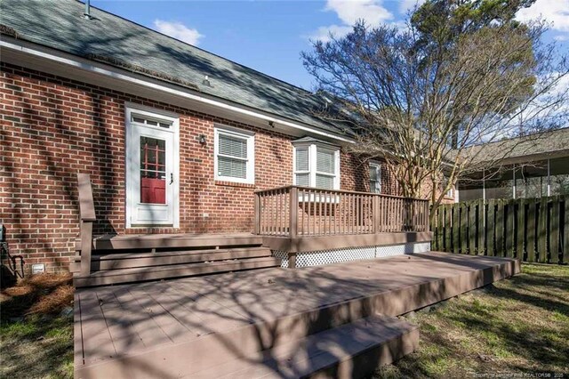 view of exterior entry featuring a wooden deck