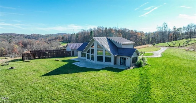 rear view of house with a yard and a patio area