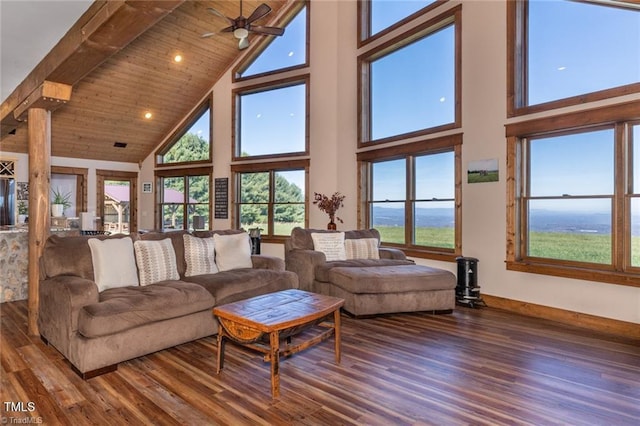 living room featuring a high ceiling, hardwood / wood-style flooring, ornate columns, and ceiling fan