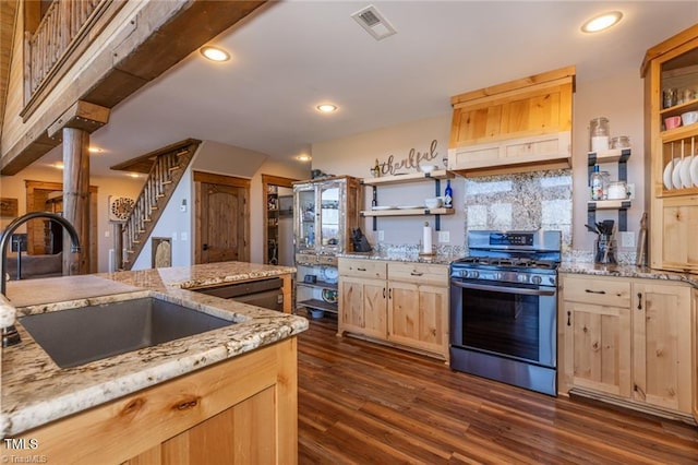 kitchen featuring light stone countertops, light brown cabinets, gas stove, and sink