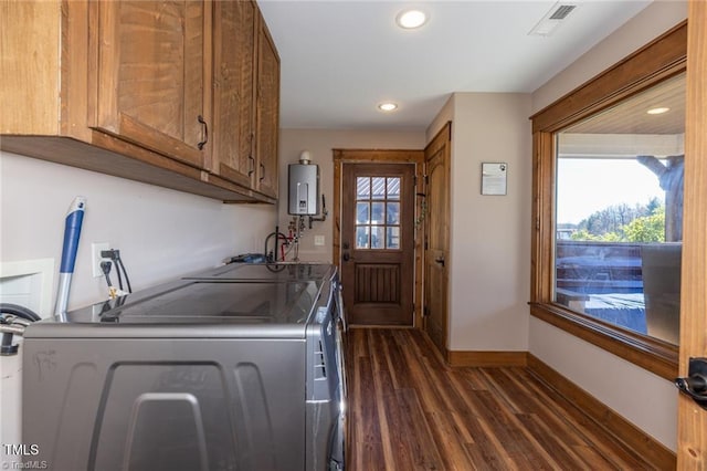 laundry area featuring cabinets, dark hardwood / wood-style flooring, washer and dryer, and water heater