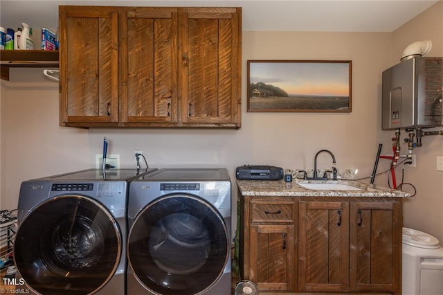 washroom featuring cabinets, independent washer and dryer, sink, and water heater