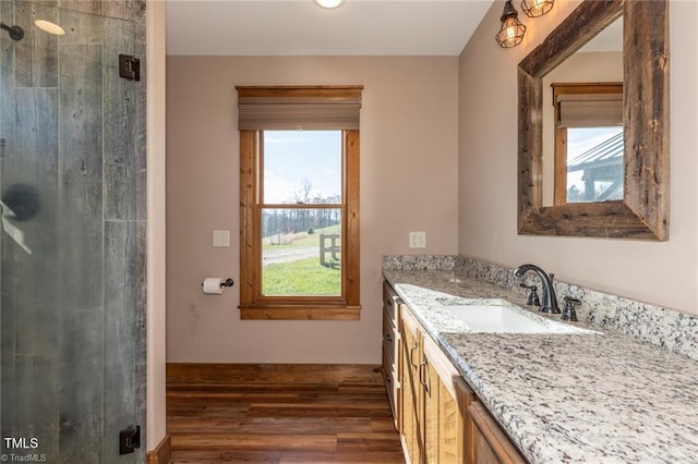 bathroom with hardwood / wood-style flooring, vanity, a shower with door, and a wealth of natural light