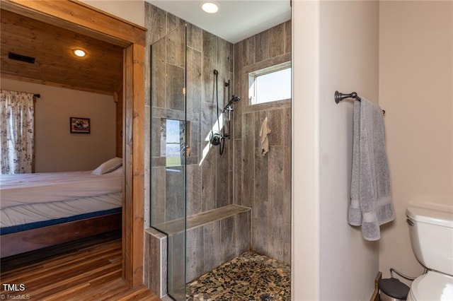 bathroom with a tile shower and toilet