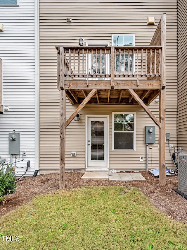 back of house with a yard, a patio, a wooden deck, and central air condition unit