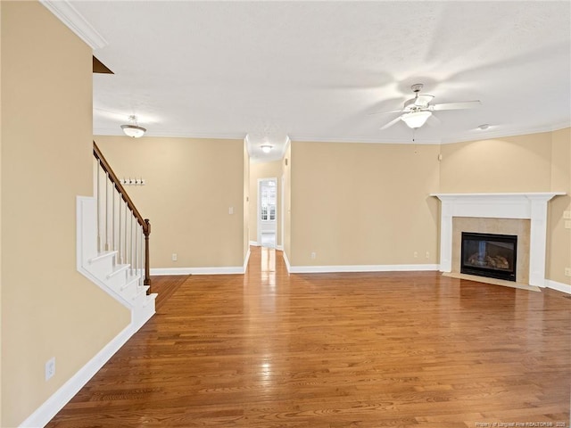 unfurnished living room featuring hardwood / wood-style floors, ceiling fan, and crown molding