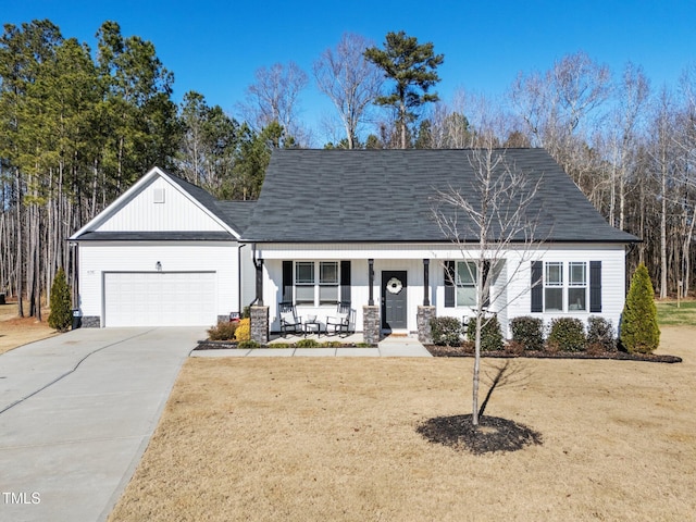 view of front of property featuring a garage, covered porch, and a front lawn