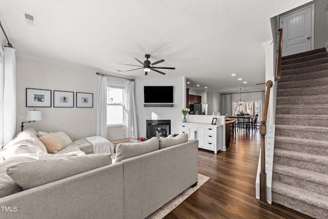 living room featuring ceiling fan, dark hardwood / wood-style floors, and ornamental molding