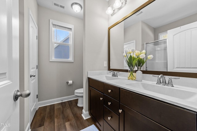 bathroom with plenty of natural light, toilet, wood-type flooring, and vanity