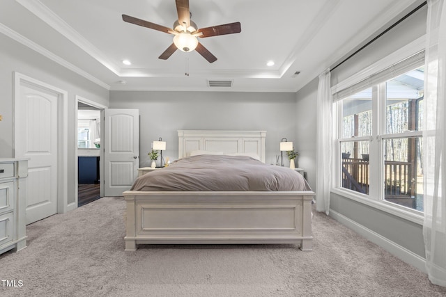 carpeted bedroom with a raised ceiling, ceiling fan, and crown molding