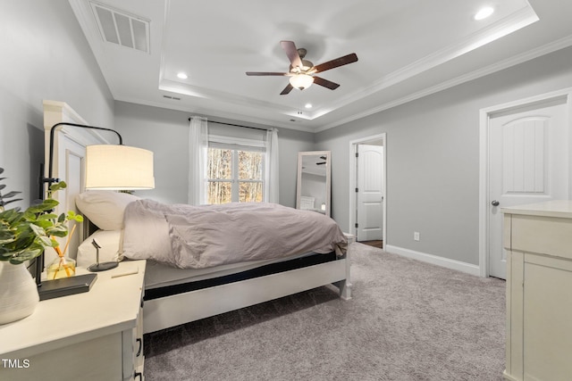 carpeted bedroom with ceiling fan, a raised ceiling, and crown molding