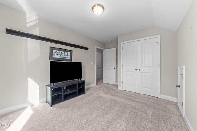 carpeted bedroom featuring a closet and lofted ceiling