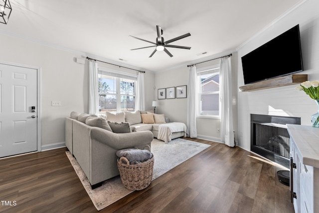 living room featuring dark hardwood / wood-style flooring, ceiling fan, and ornamental molding