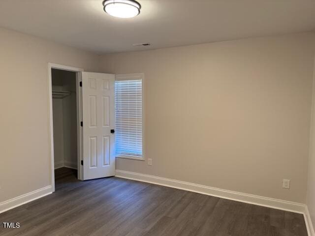 unfurnished bedroom featuring dark hardwood / wood-style flooring and a closet