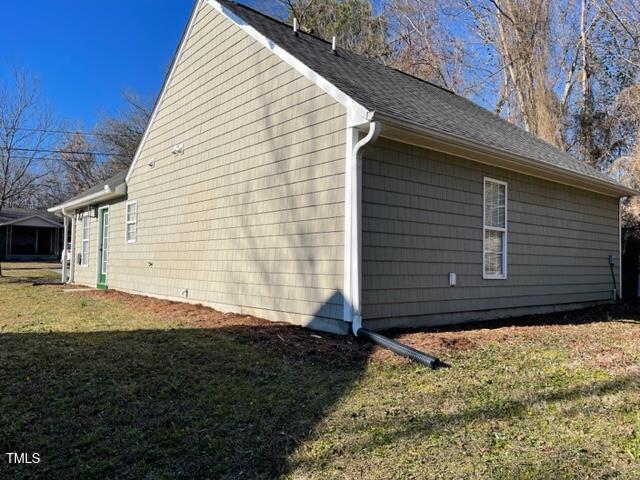 view of side of property with a lawn