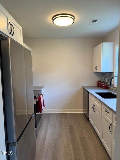 415 Sowell St, Durham, NC 27701 - kitchen featuring appliances with stainless steel finishes, dark wood finished floors, and white cabinets