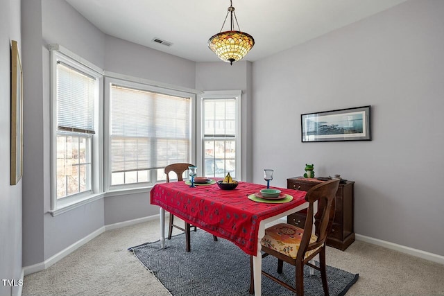 dining space featuring plenty of natural light, baseboards, visible vents, and light carpet