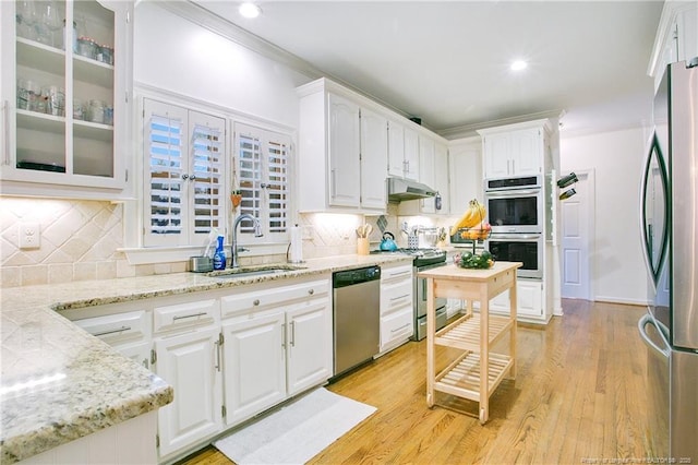 kitchen featuring white cabinets, sink, light wood-type flooring, light stone counters, and stainless steel appliances