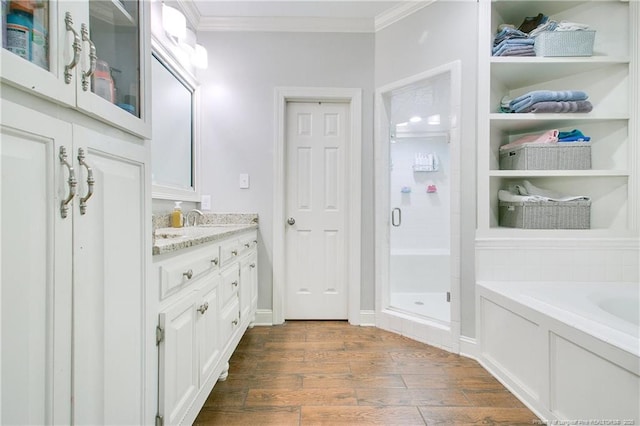 bathroom featuring independent shower and bath, vanity, wood-type flooring, and ornamental molding