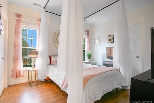 bedroom featuring wood-type flooring and crown molding