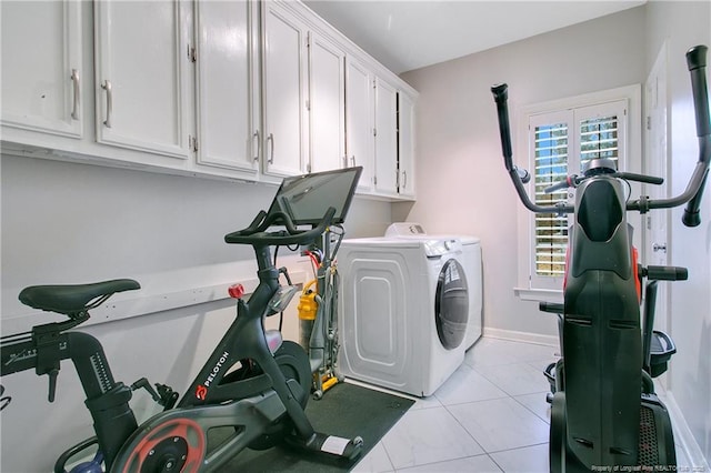 clothes washing area featuring cabinets, independent washer and dryer, and light tile patterned floors