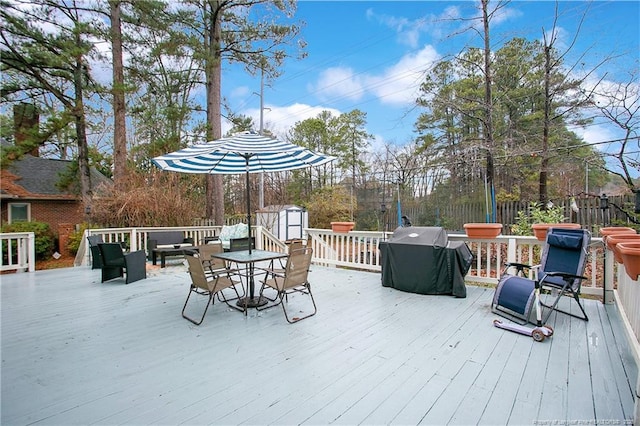 wooden terrace with grilling area and a storage unit