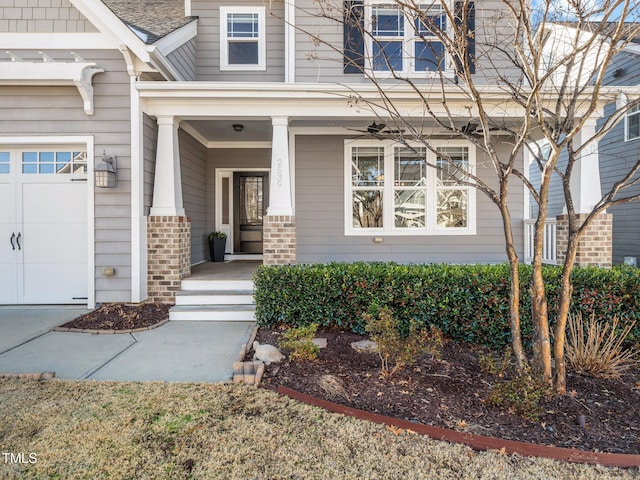 view of exterior entry featuring covered porch and a garage