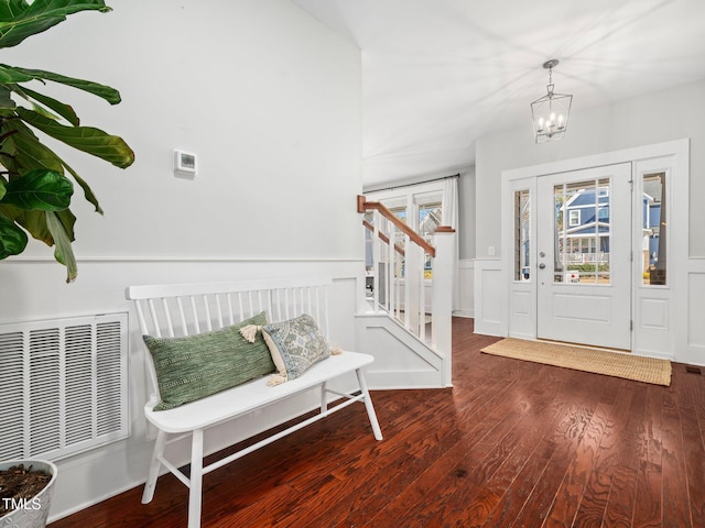 foyer entrance featuring dark wood-type flooring and an inviting chandelier