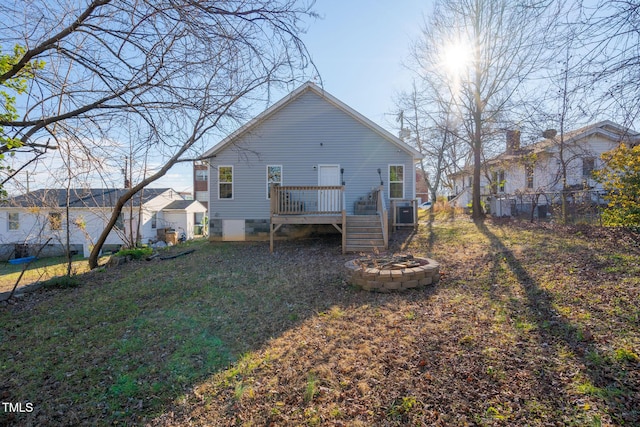 rear view of house featuring a deck, an outdoor fire pit, and a lawn