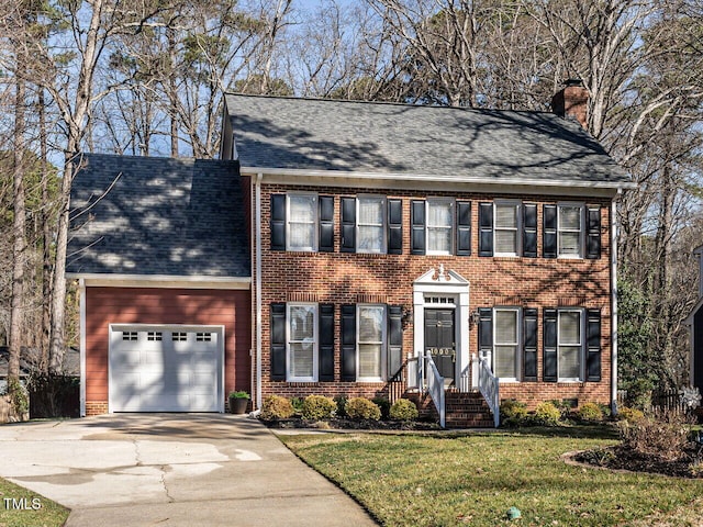 colonial home featuring a front lawn and a garage