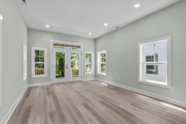 spare room featuring french doors and light hardwood / wood-style flooring