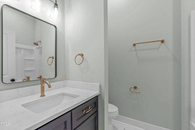 bathroom with vanity, a shower, and toilet