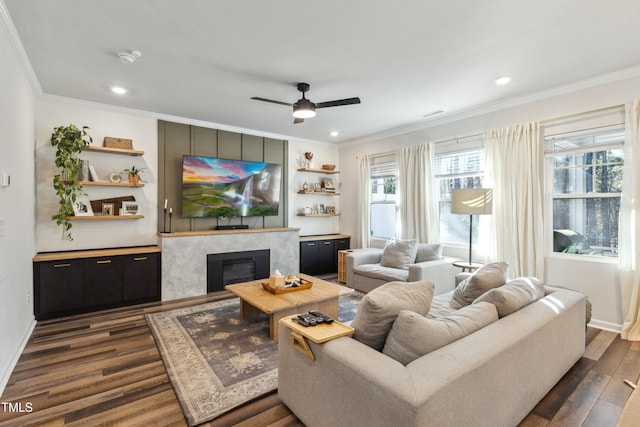 living room with ceiling fan, crown molding, dark wood-type flooring, and a wealth of natural light