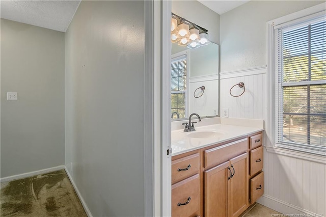 bathroom with vanity, a textured ceiling, and an inviting chandelier