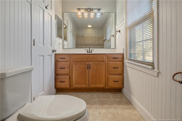 bathroom featuring wooden walls, tile patterned flooring, vanity, and walk in shower