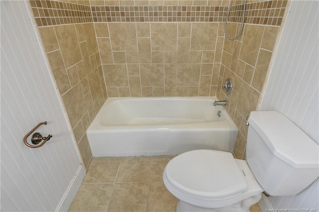 bathroom featuring tile patterned flooring, toilet, and tiled shower / bath