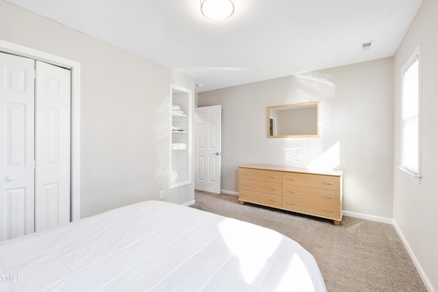 bedroom with a closet and light colored carpet