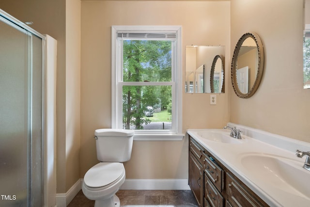 bathroom with walk in shower, plenty of natural light, vanity, and toilet