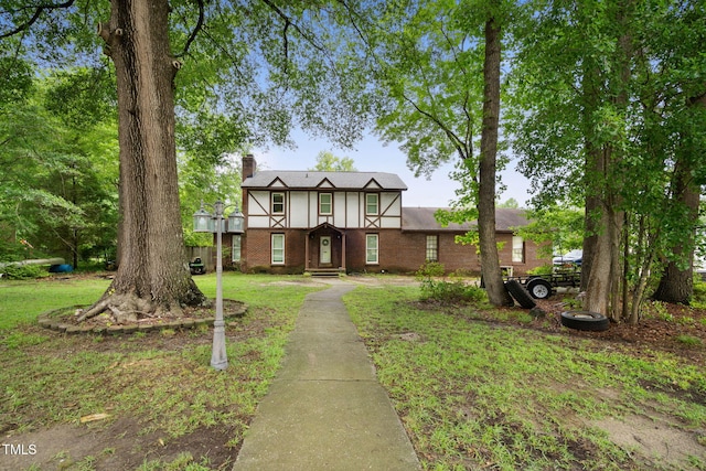 tudor-style house with a front yard