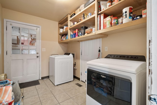 laundry room with separate washer and dryer and light tile patterned flooring