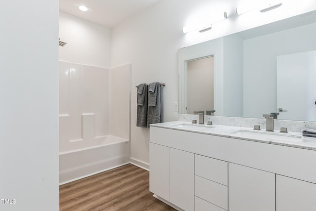 bathroom with wood-type flooring, vanity, and shower / washtub combination