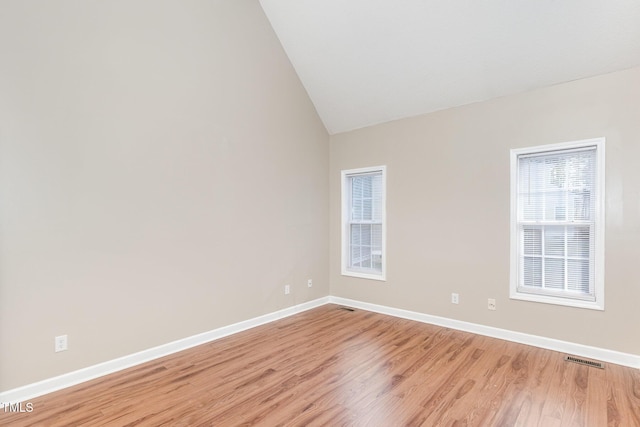 empty room featuring light hardwood / wood-style flooring and lofted ceiling