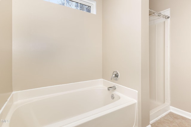 bathroom with a bath and tile patterned floors