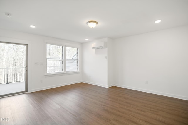 empty room with an AC wall unit and dark wood-type flooring