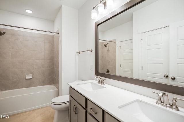 full bathroom featuring toilet, tile patterned flooring, vanity, and tiled shower / bath