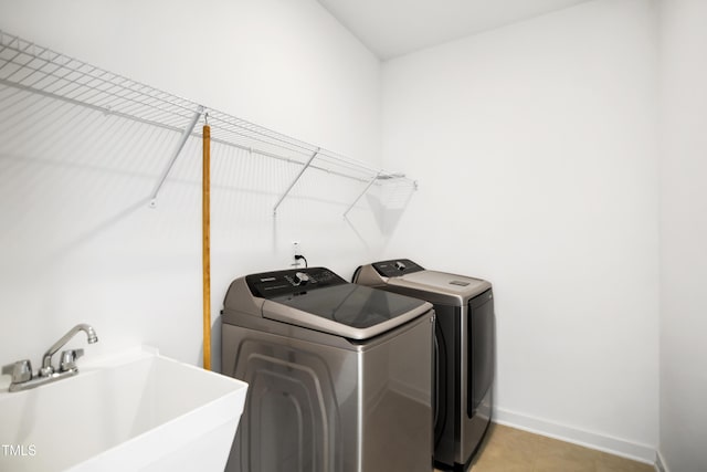 clothes washing area featuring sink and washing machine and clothes dryer